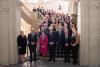 A group photo of the participants of the conference in the landing of an ornamented staircase